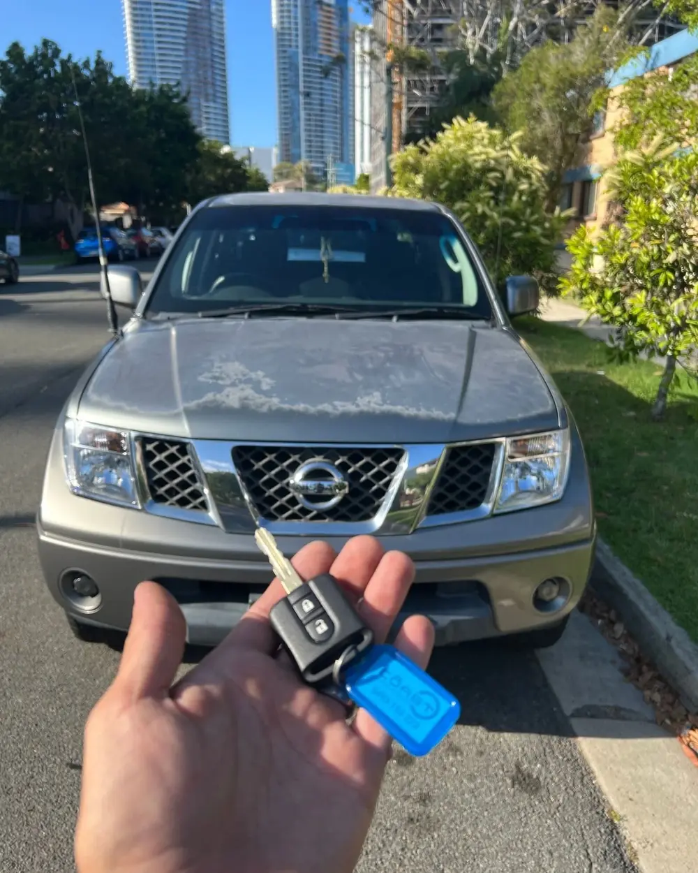 Car key held in front of a parked four-wheel drive